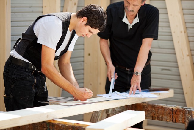 Ausbildung Handwerk - Meister zeigt Auszubildendem Holzarbeiten